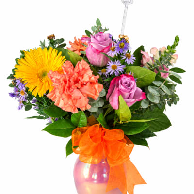 Colorful bouquet in a pink vase with an orange ribbon