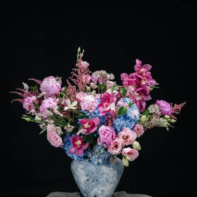 Pink and blue floral arrangement in a ceramic vase