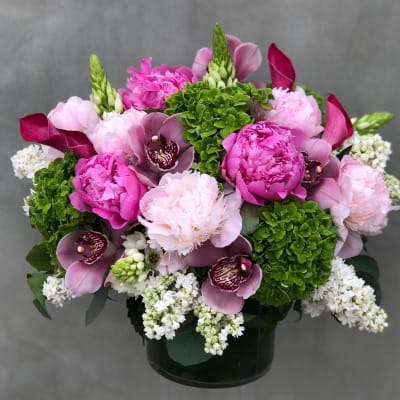 Pink and white floral arrangement in a dark vase