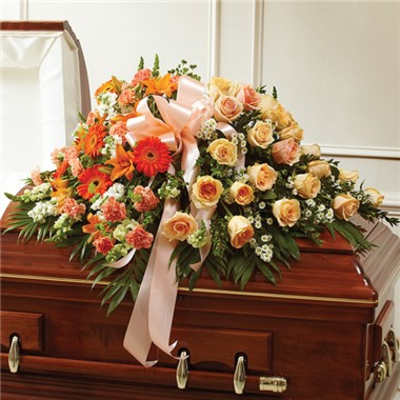 Floral casket spray with peach roses and orange gerbera daisies