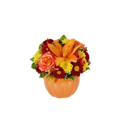 Orange lilies and mixed mums in a pumpkin-shaped vase