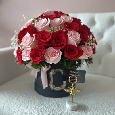 Bouquet of red and pale pink roses in a black hat box