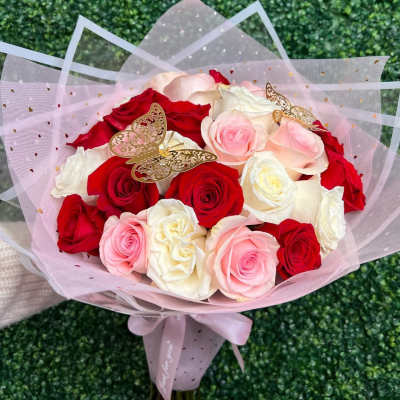 Bouquet of red, pink, and white roses wrapped in pink tulle