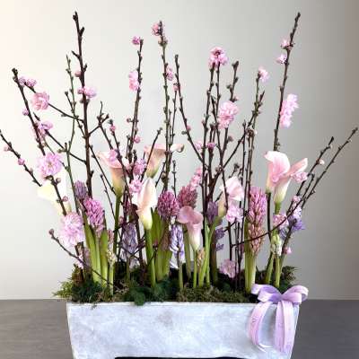 Pink calla lilies and blossoms in a rectangular silver planter