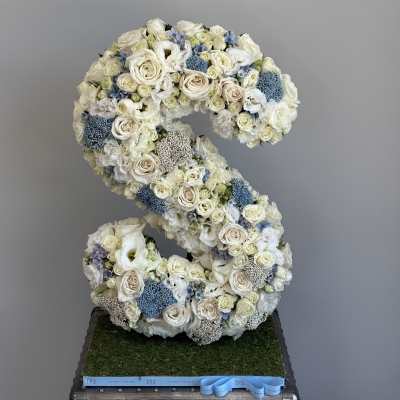 Large floral letter S made of white and pale blue flowers