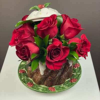 Bouquet of red roses arranged in a decorative cake-shaped container