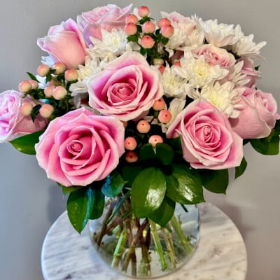 Pink roses and white daisies in a clear glass vase