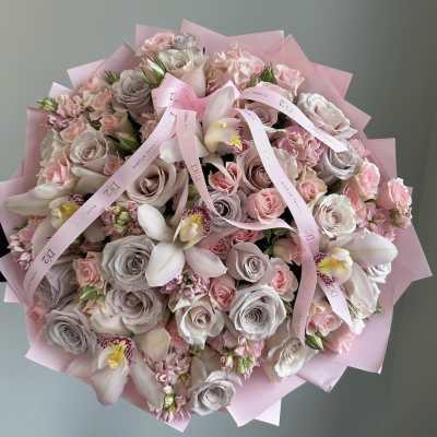 Large bouquet of pink and blush roses with orchids wrapped in pink paper