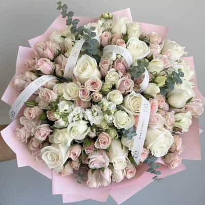 Large bouquet of white and blush roses wrapped in pink paper