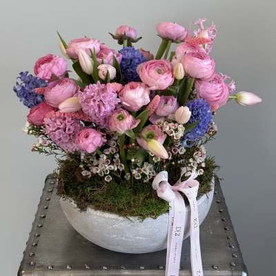 Pink and blue mixed flower arrangement in a round silver bowl
