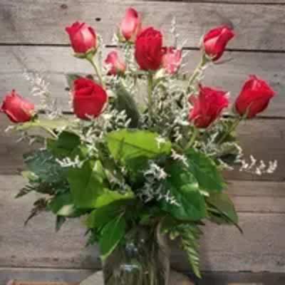 Red roses arranged in a clear glass vase
