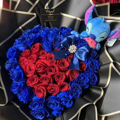 Heart-shaped bouquet of red and blue roses with a plush toy