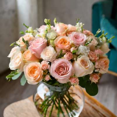 Bouquet of blush and peach roses in a clear glass vase