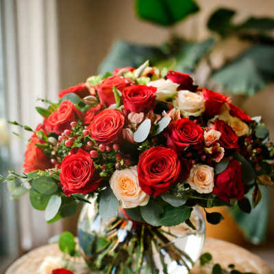 Bouquet of red and cream roses in a clear glass vase