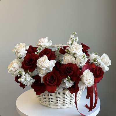 Basket of red and white roses with small white flowers
