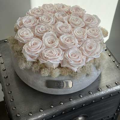 Round arrangement of pale pink roses in a silver box