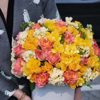 Bouquet of yellow, pink, and white roses in a white box
