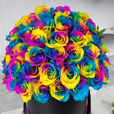 Rainbow-colored rose bouquet in a black hat box