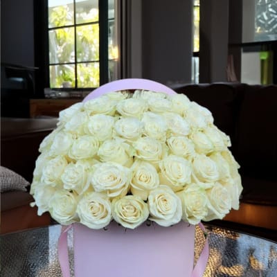 Bouquet of white roses in a pink round box with ribbon handles
