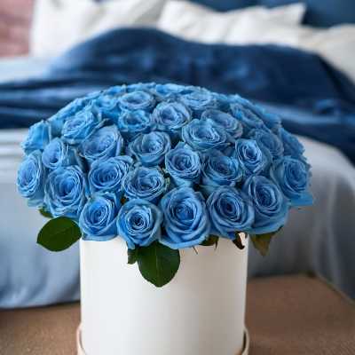 Blue roses arranged in a white round box