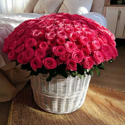 Large basket of bright pink roses on a bed