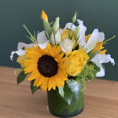 Sunflower and yellow rose bouquet in a glass vase