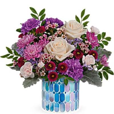 Bouquet of purple and white flowers in a blue mosaic vase