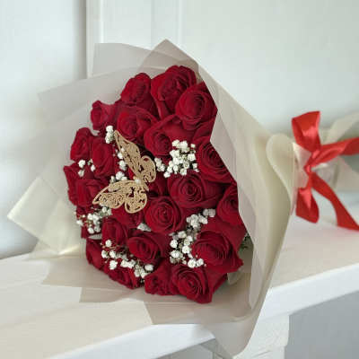 Bouquet of red roses with baby's breath in cream wrapping