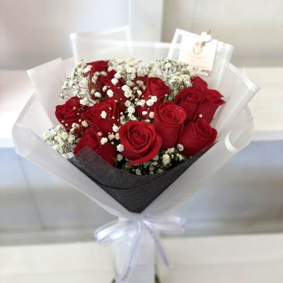 Bouquet of red roses with white baby's breath in white wrap