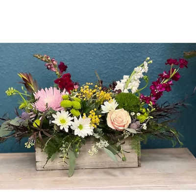 Mixed floral arrangement in a wooden box with pink, white, and burgundy blooms