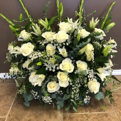 Large white floral arrangement with roses and lilies