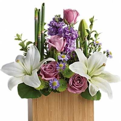 Arrangement of white lilies, pink roses, and purple flowers in a wooden box
