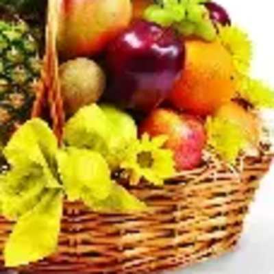 Fruit basket with apples, grapes, and yellow flowers in a wicker basket