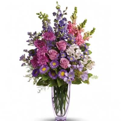 Purple and pink mixed bouquet in a tall glass vase