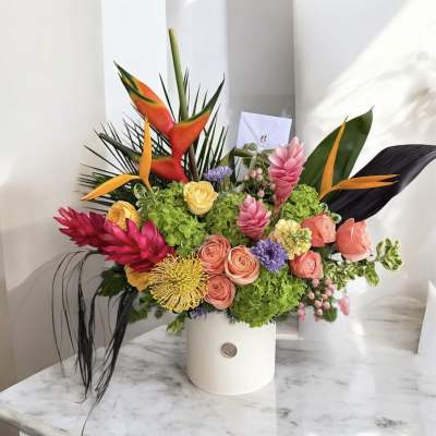 Tropical bouquet in a white hatbox with pink and orange flowers