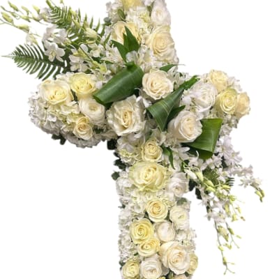 White rose and orchid cross arrangement with green leaves