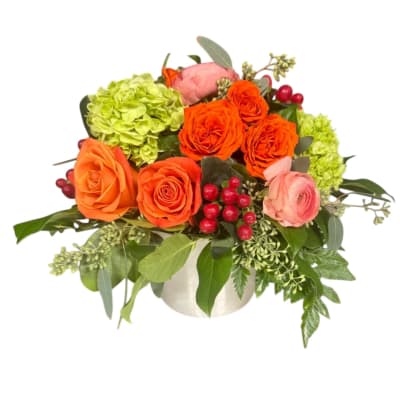 Orange and pink roses with green hydrangeas in a white vase