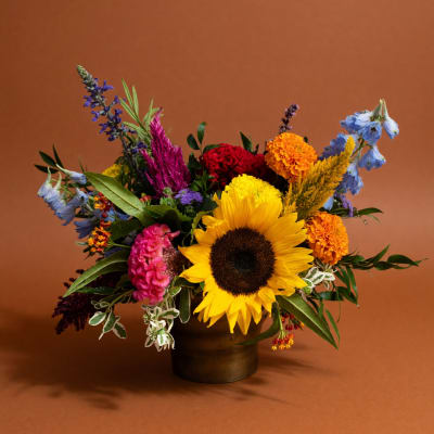 Colorful mixed bouquet with a sunflower in a dark vase