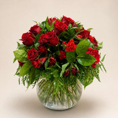 Red roses and carnations in a clear glass vase