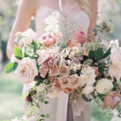 Bride holding a pastel bouquet of roses and mixed blooms