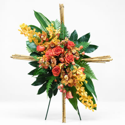 Tropical floral standing spray with orange roses and yellow orchids on a bamboo easel