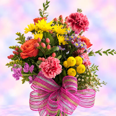 Colorful bouquet of mixed flowers with a pink ribbon bow