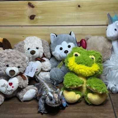 Assorted plush animals including teddy bears, a frog, a unicorn, and a dog