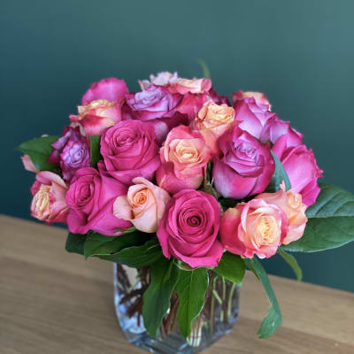 Pink and peach roses arranged in a clear glass vase