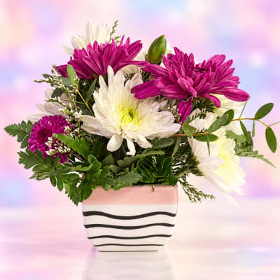 Pink and white chrysanthemum bouquet in a striped ceramic vase
