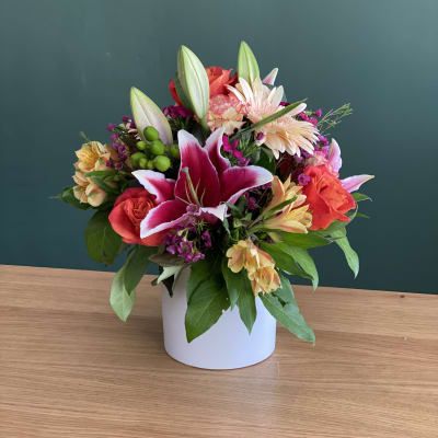 Mixed bouquet with lilies and roses in a white vase