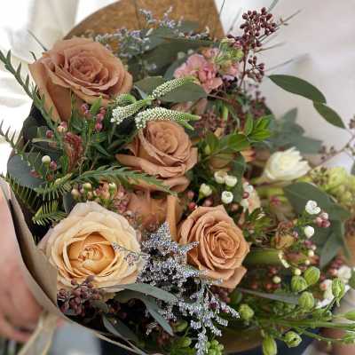 Bouquet of peach roses with small pink and white filler flowers