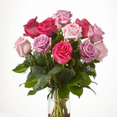 Bouquet of pink and lavender roses in a clear glass vase