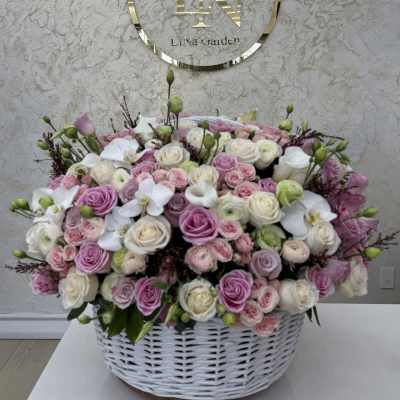 Large basket arrangement of pink and white roses with white orchids