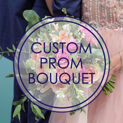Round bouquet of pink and white roses held by a couple in prom attire
